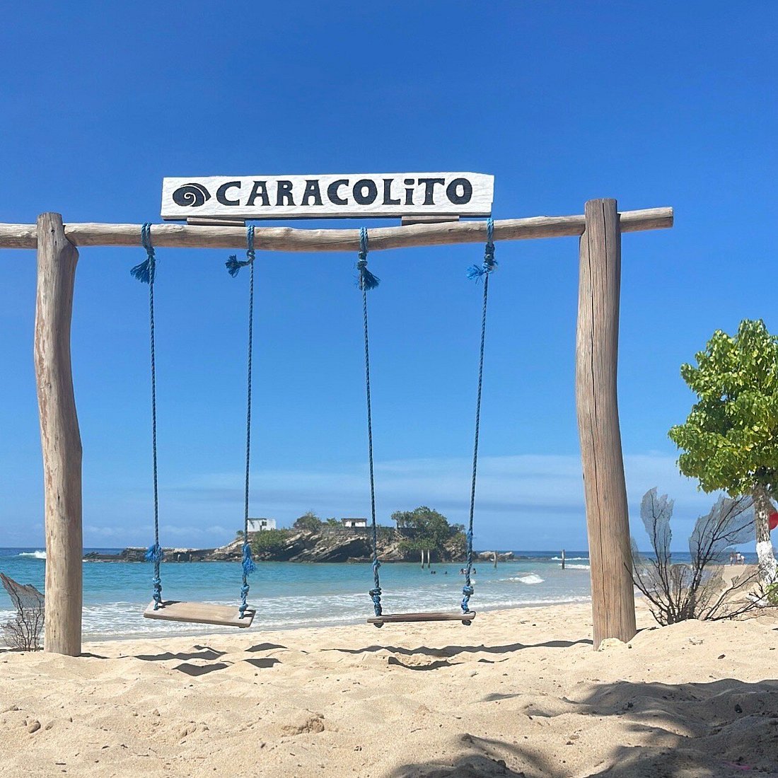 Cartel y columpio de Playa Caracolito